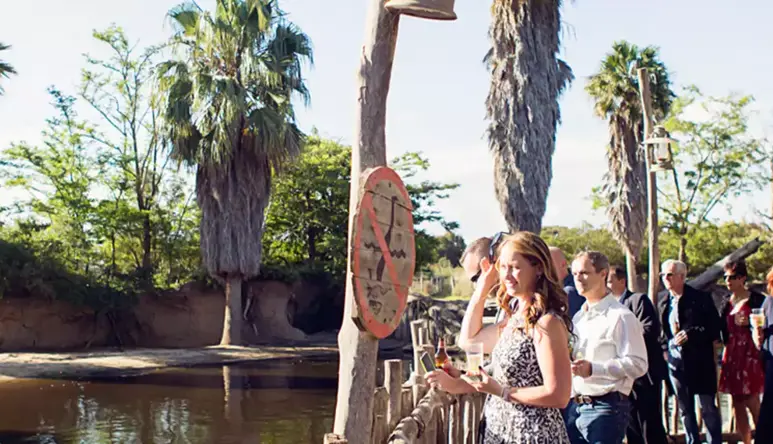 A group of people standing on a Boardwalk overlooking a river.