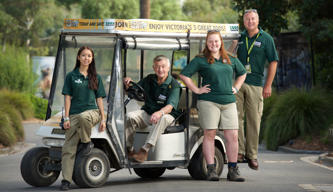 Four volunteers stand proudly with the buggy