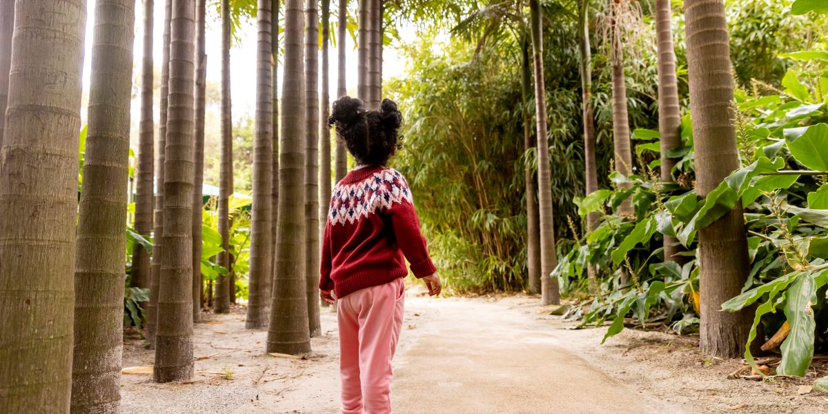 A young guest stands in the Bamboo Forest, with her back turned to the camera.