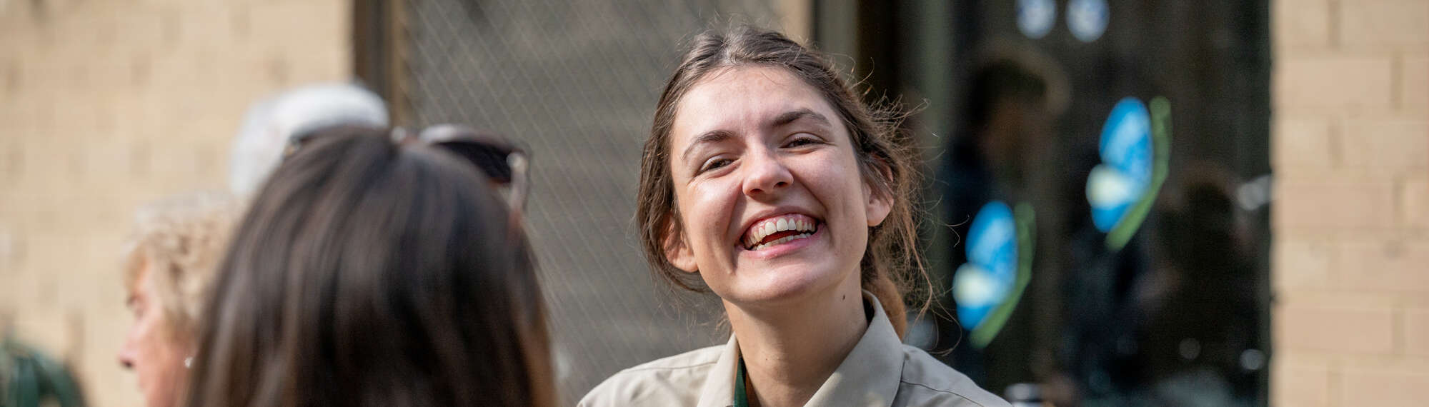A volunteer smiling at the camera, in the company of five others.