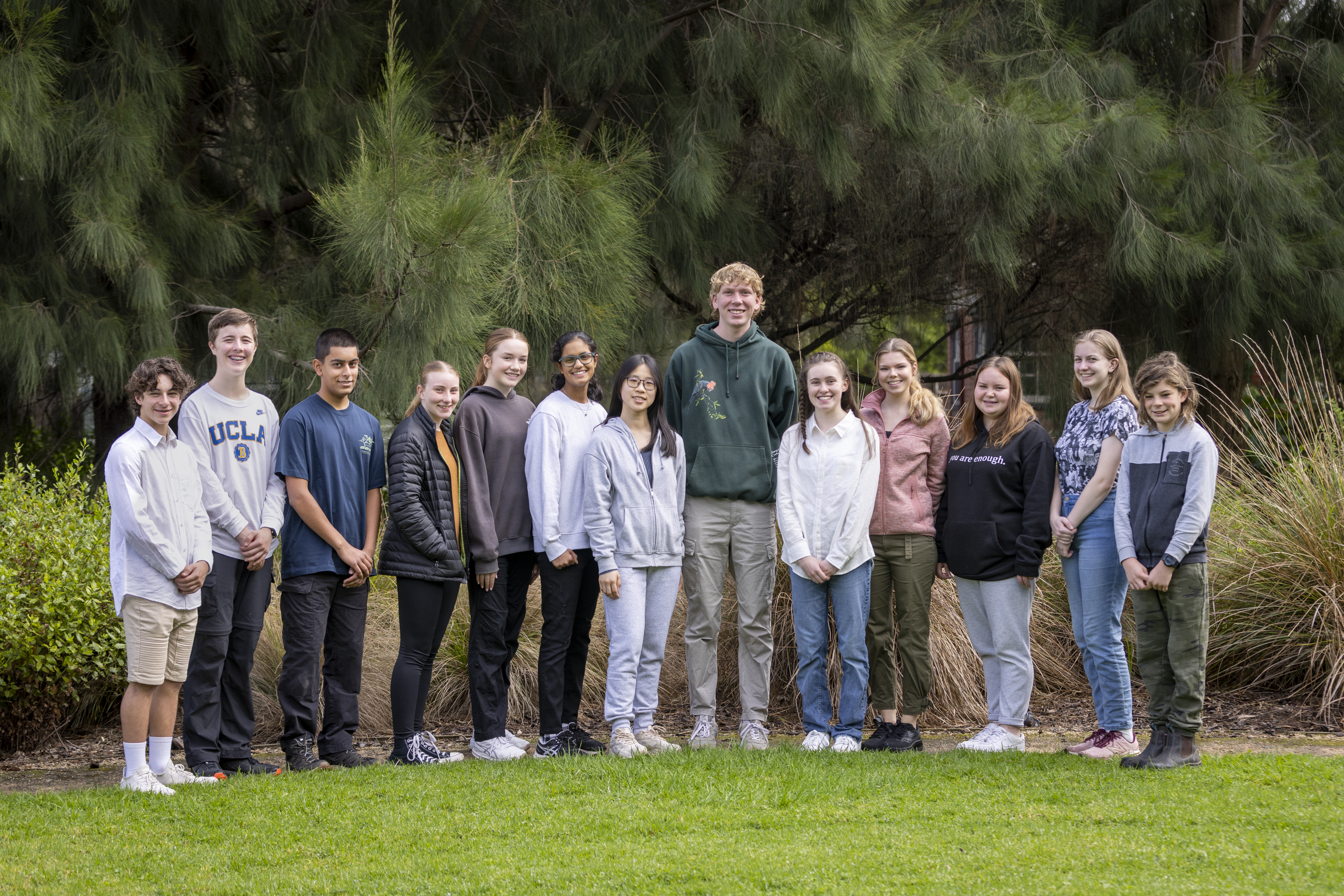 The thirteen then-active members of ZV's Youth Advisory Committee, rowed up trees and smiling to the camera.