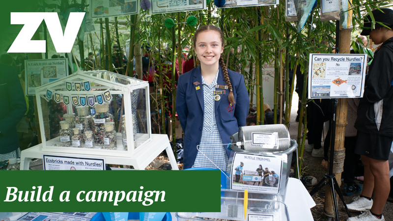 "Build A Campaign": A school student stands smiling behind her craft School showcase.