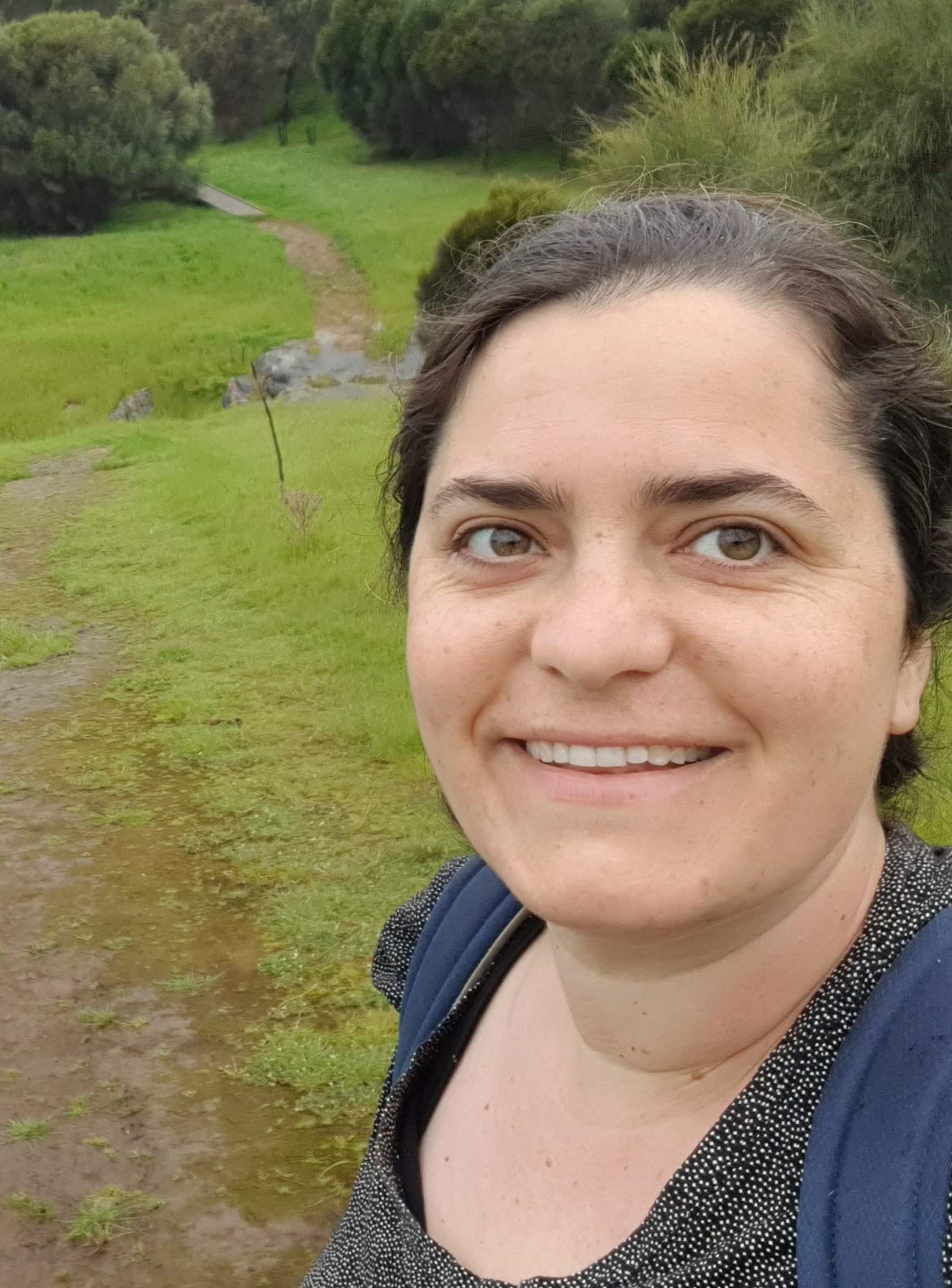 Officer Emily taking a "selfie" in a wind-swept forest clearing, 