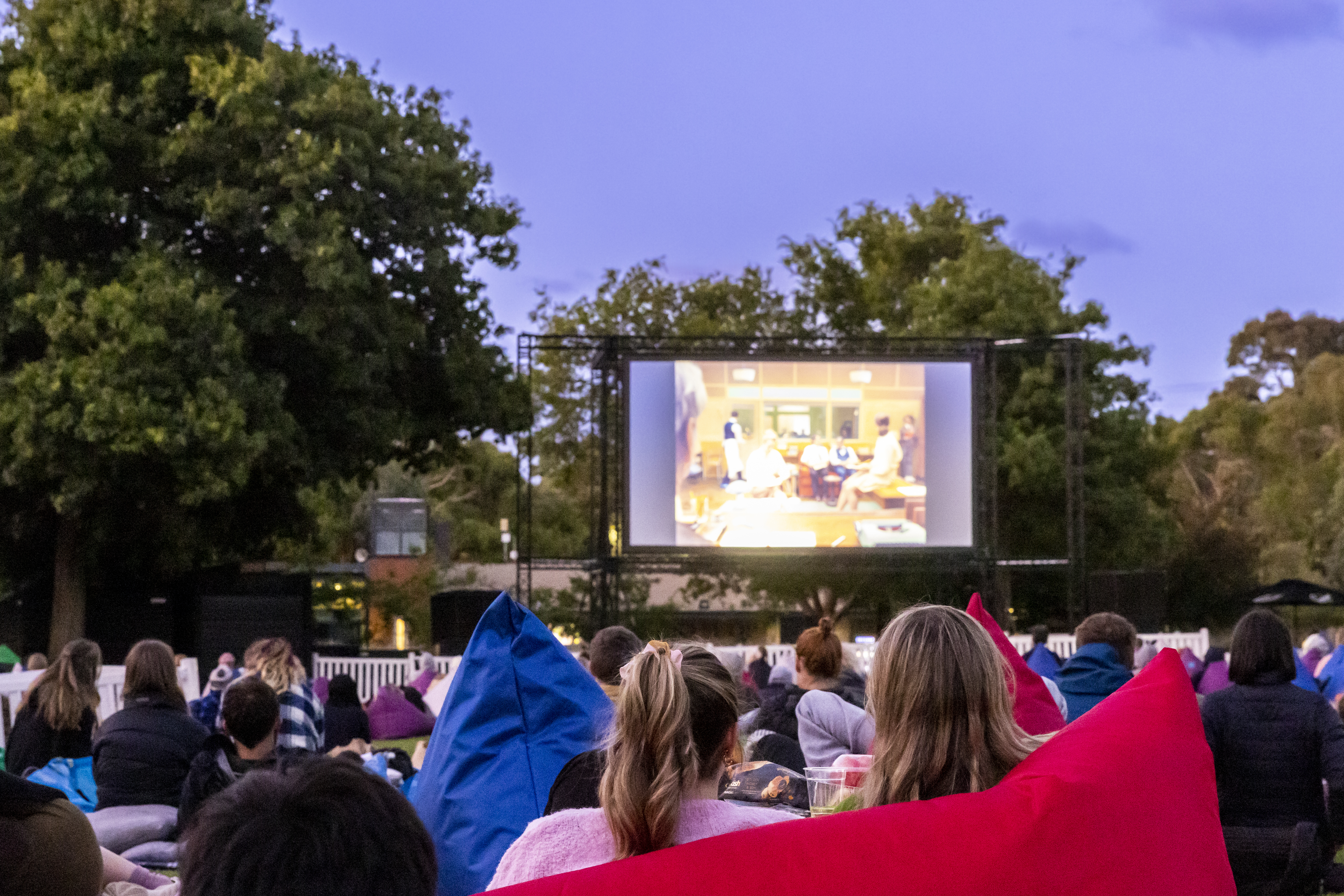 An outdoor movie screening on Melbourne Zoo's North Lawn at dusk.