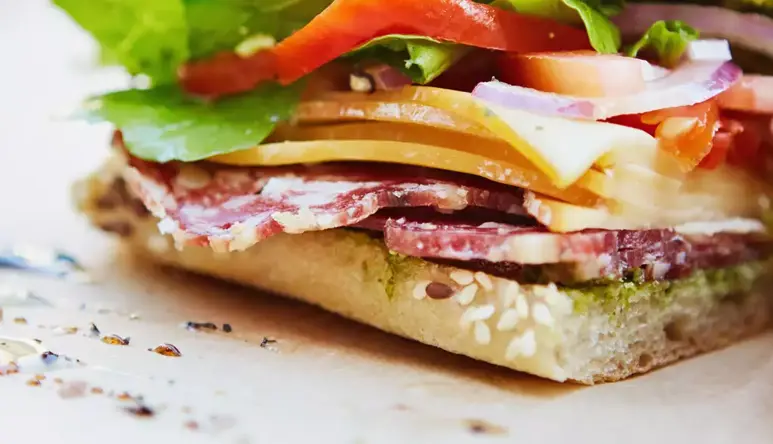 Close-up photo of a focaccia cut in two showing various ingredients.