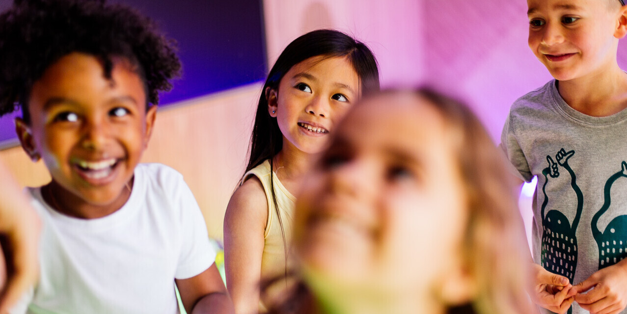 Five young guests happily enjoying themselves in the Frog Disco, while looking left.