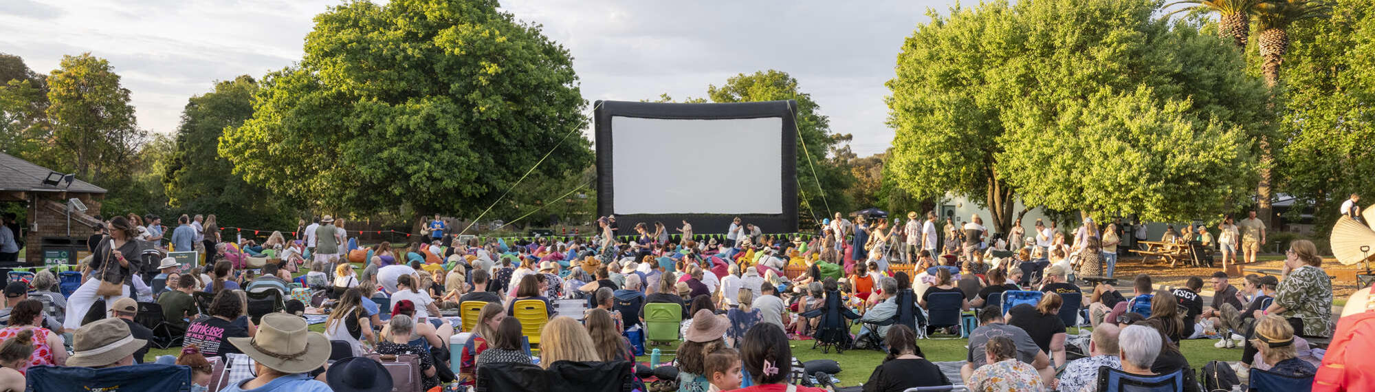A view of the Zoovie Doco-Night event held at Melbourne Zoo, with a crowd gathered before the outdoor screen.