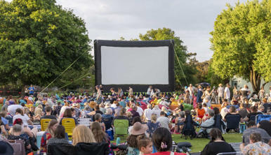 A view of the Zoovie Doco-Night event held at Melbourne Zoo, with a crowd gathered before the outdoor screen.