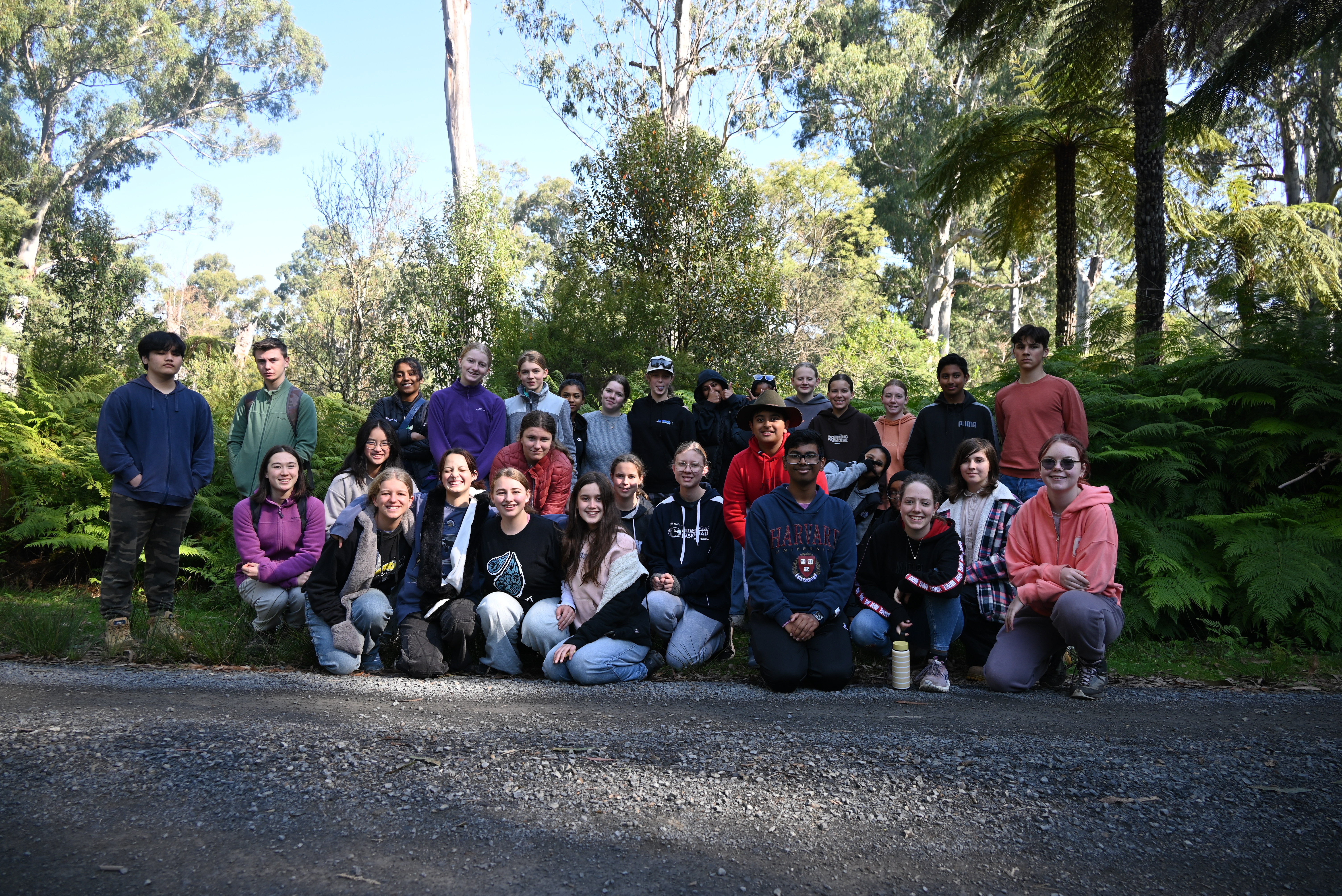 Thirty-two students (youth conservation leaders) posing for the camera, against a leafy backdrop.