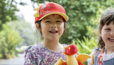 Two girls smiling, wearing Dragon Guardians merchandise items
